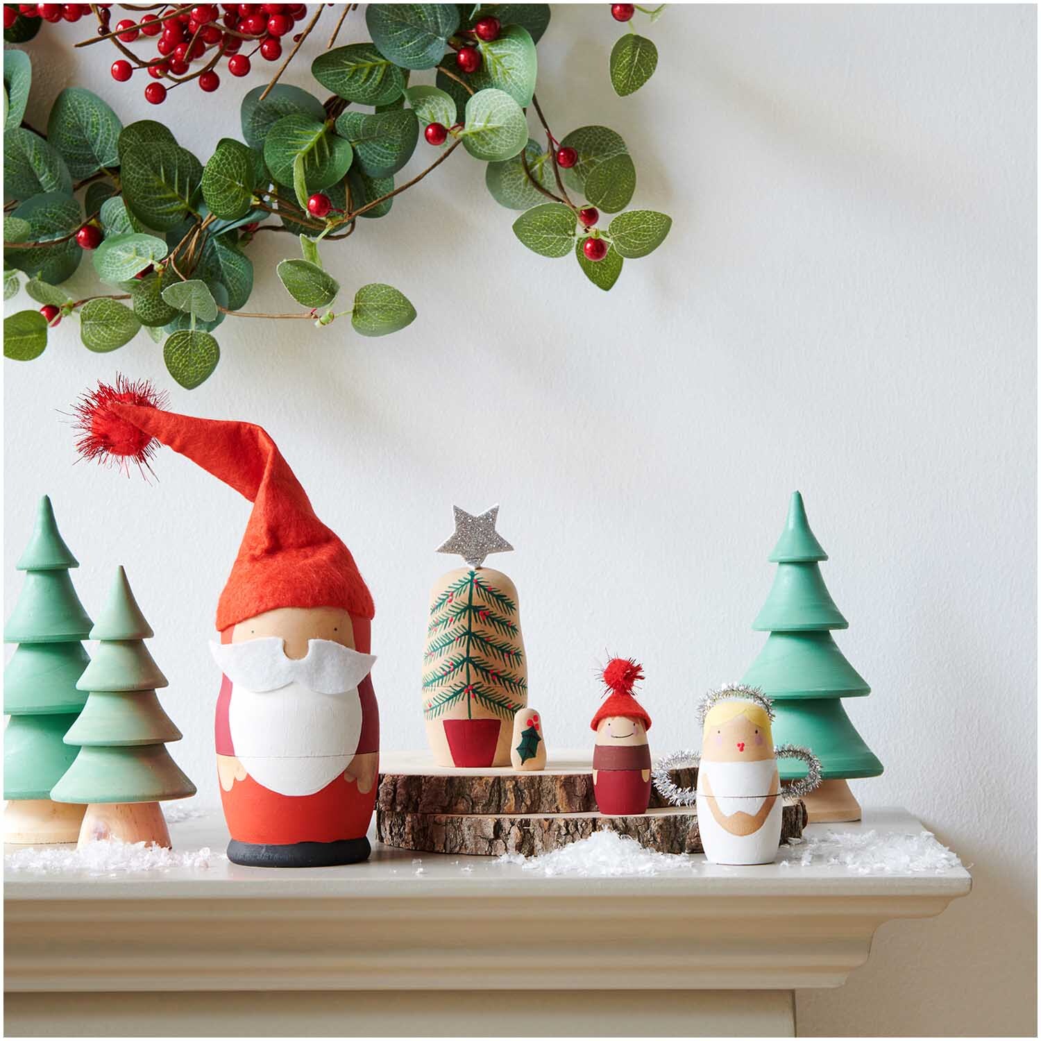Matroschka Puppenrohlinge 5 Stück von Rico Design Matroschka Puppenrohlinge 5 Stück von Rico Design auf einem Kaminsims mit Weihnachtsdekoration, darunter Tannenbäume und ein Weihnachtsmann.