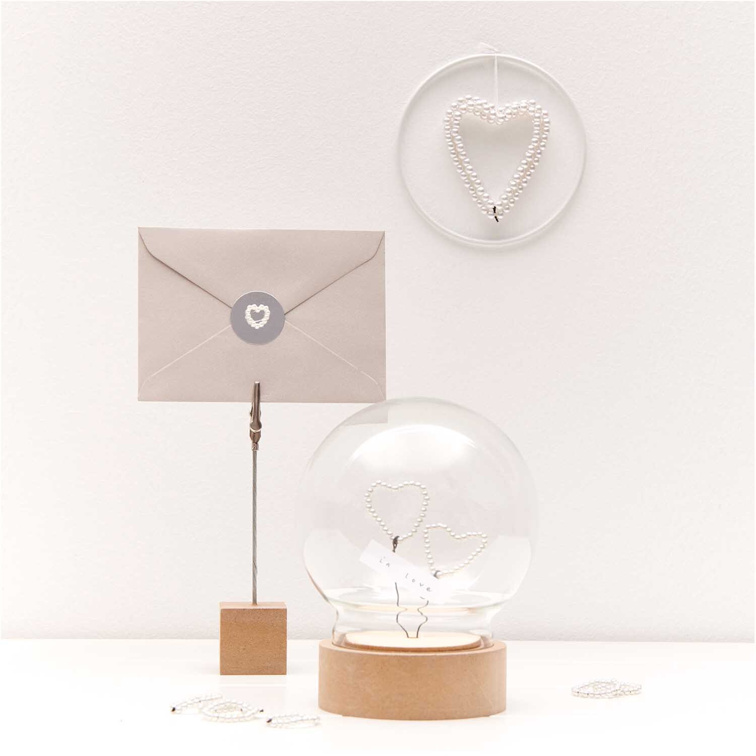 Perlenstreu Herz perlmutt 12 Stück von Rico Design Perlenstreu Herz perlmutt 12 Stück von Rico Design: Dekoratives Herz aus Perlen in einem modernen, minimalistischen Arrangement mit Brief und Glaskugel.