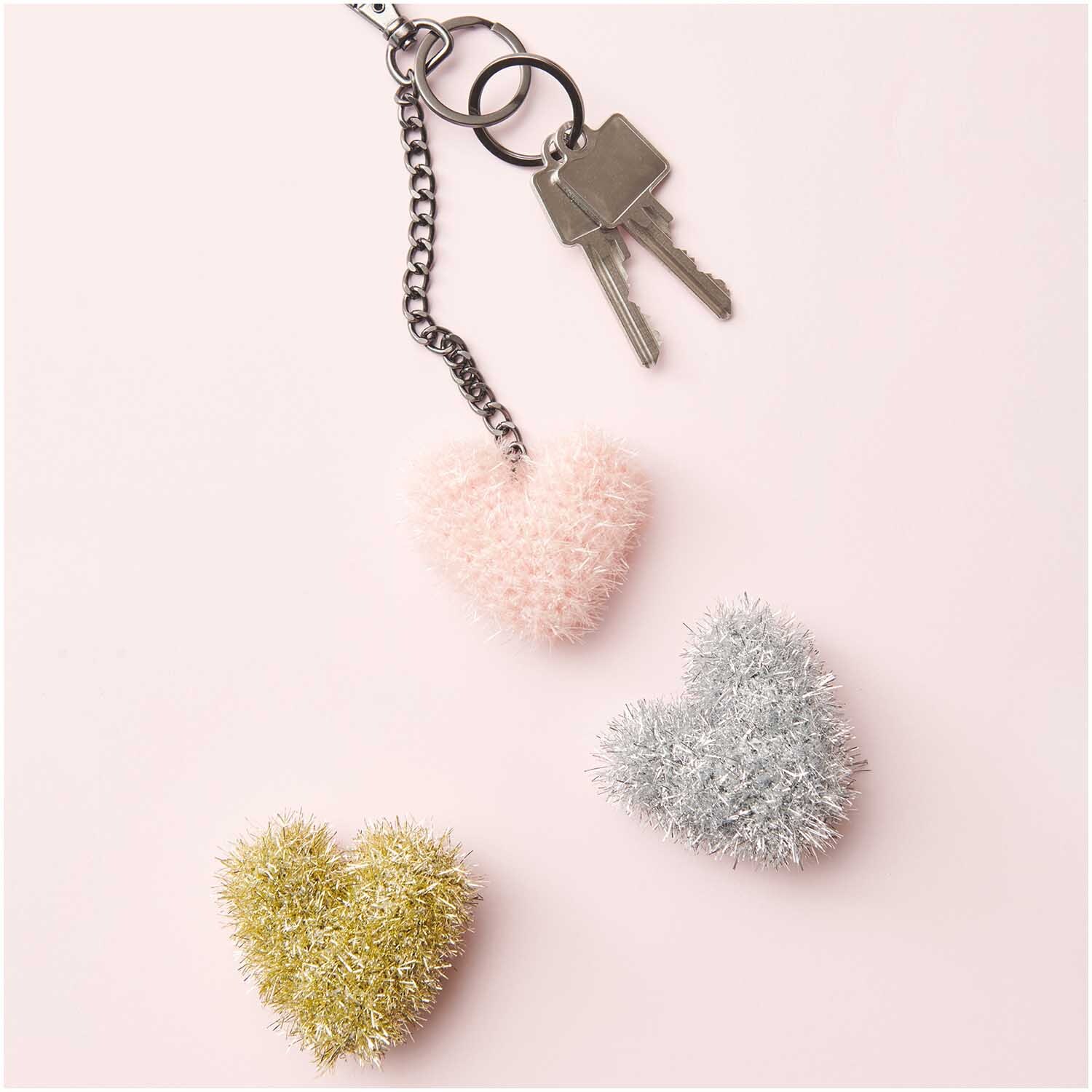 Creative Bubble Set Good Luck! 10x50g von Rico Design Creative Bubble Set Good Luck! Flauschige Herzanhänger in Rosa, Silber und Gold von Rico Design auf rosa Hintergrund.