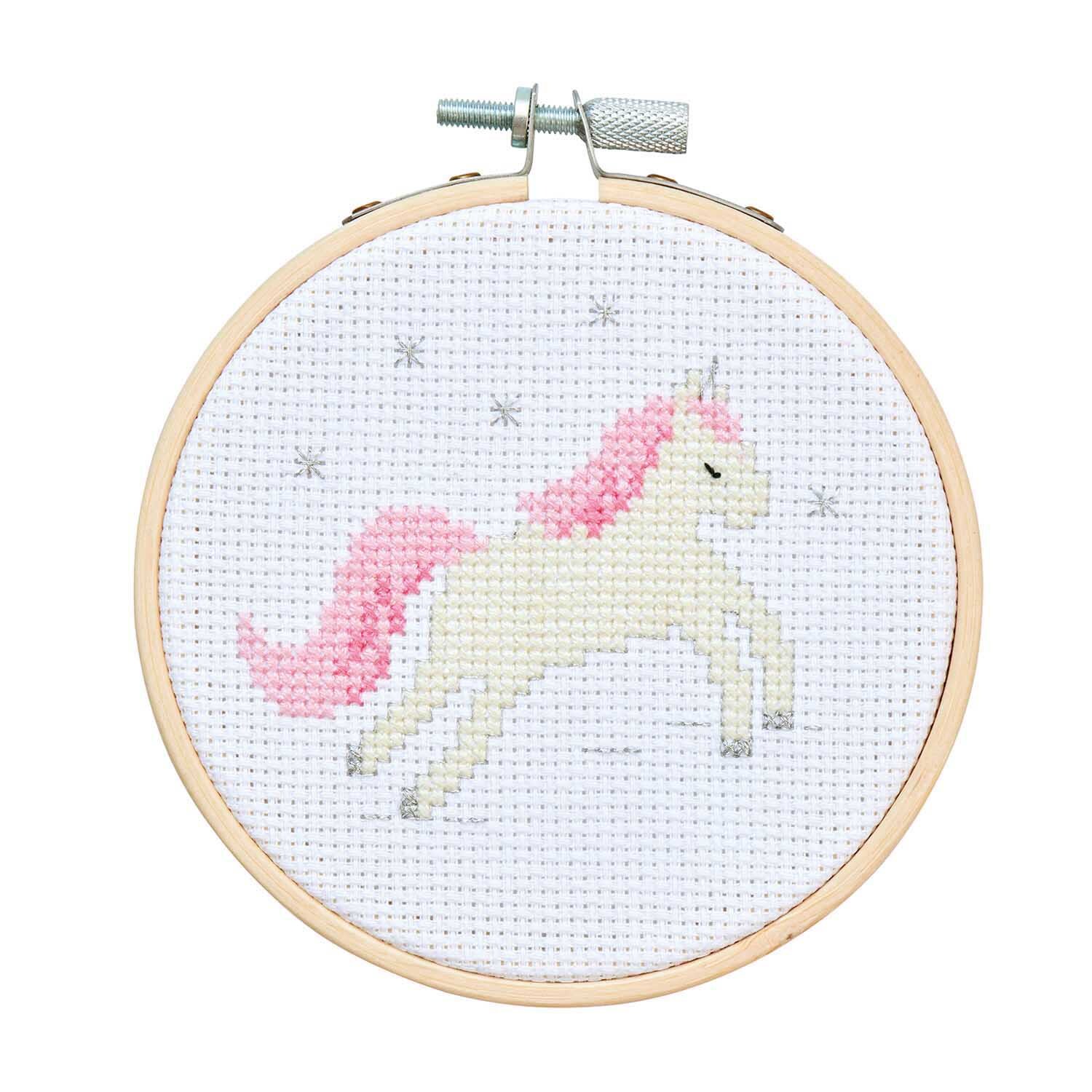 Stickpackung Mini Kit Einhorn Bild Ø 10cm zeigt ein weißes Einhorn mit rosa Mähne auf weißem Stoff.