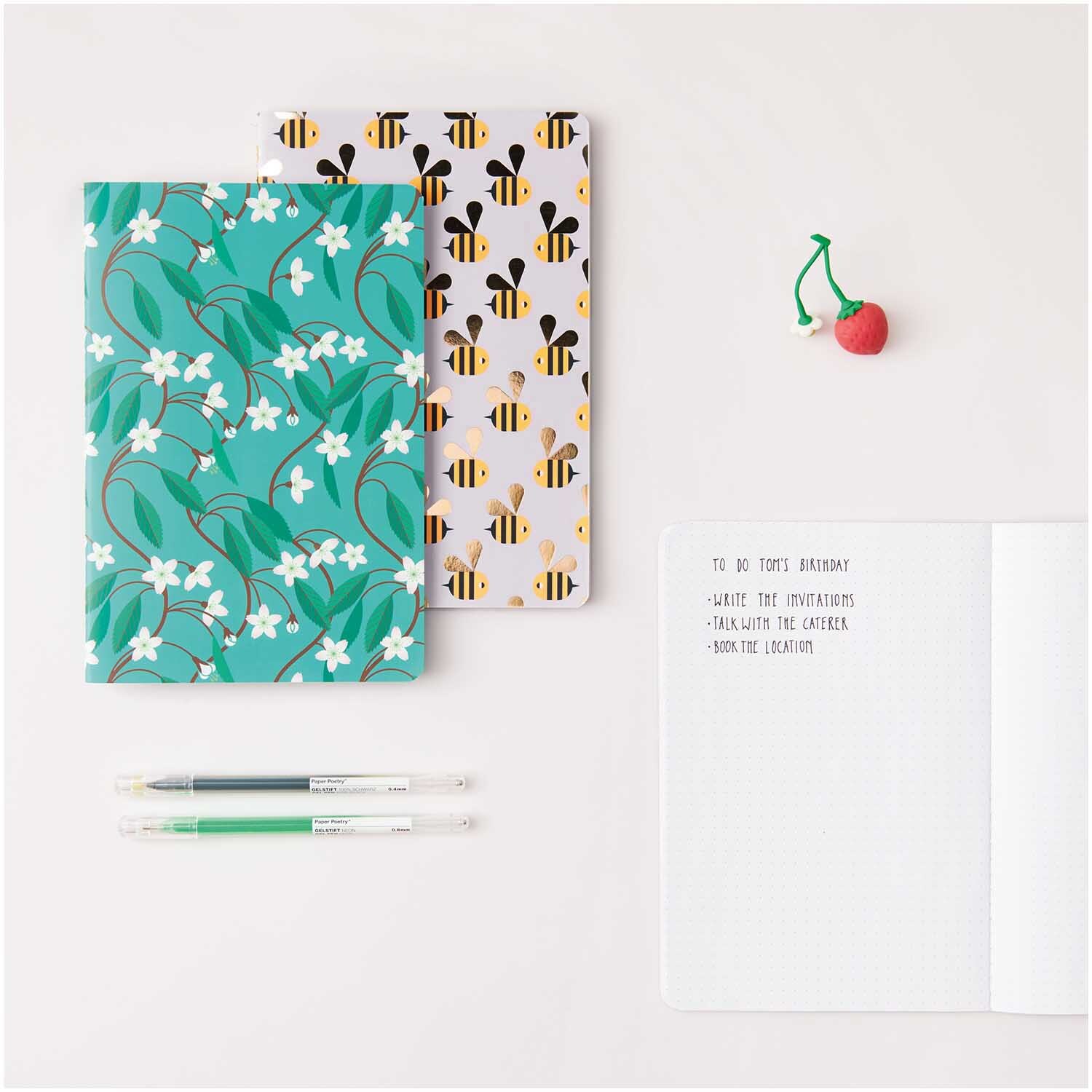 Paper Poetry Notizbücher Bienen und Blüten A5 50 Blatt 80g/m2 2 Stück von Rico Design Paper Poetry Notizbücher mit Bienen- und Blütenmuster, A5, 50 Blatt, von Rico Design, auf einem Tisch mit Stiften und Notizen.