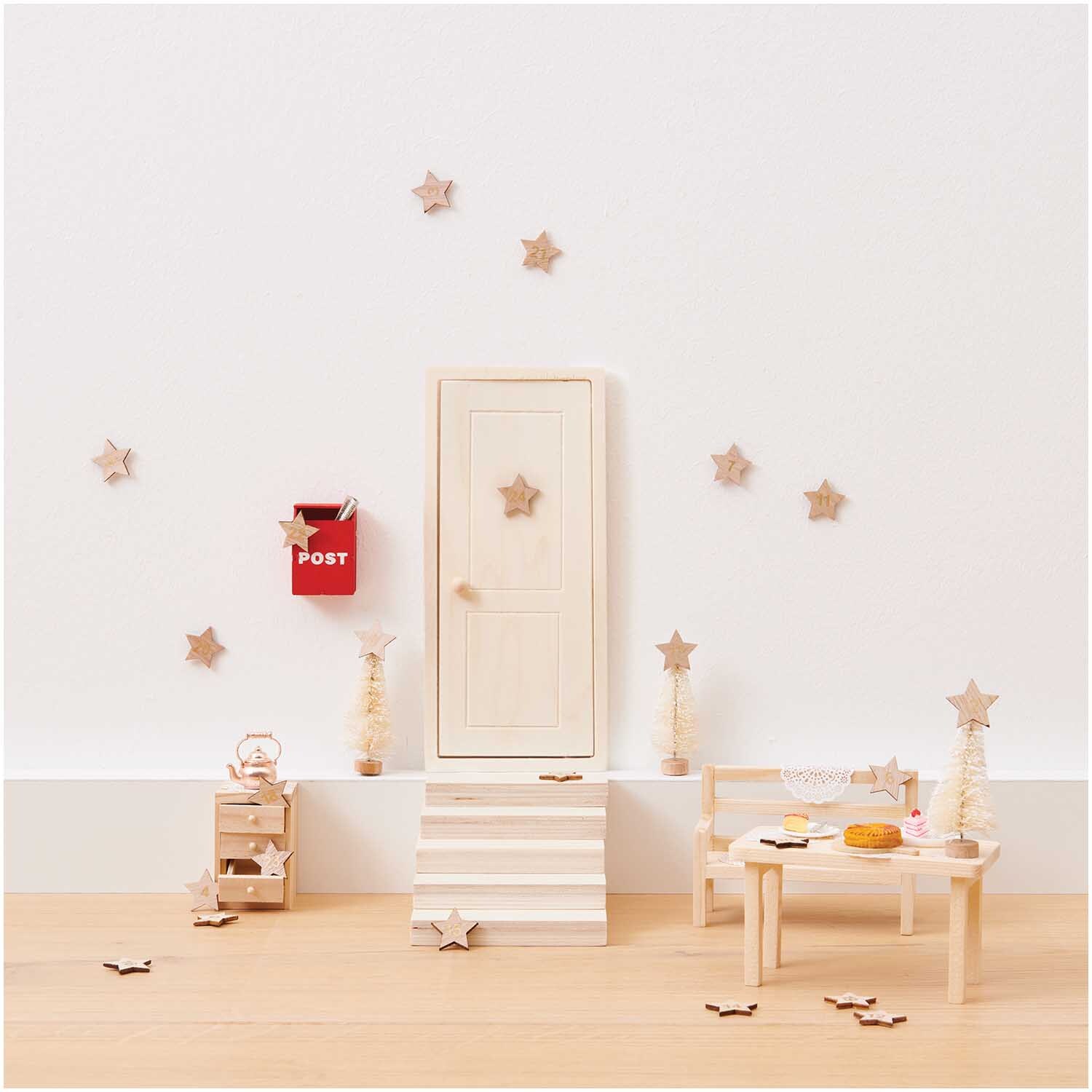 Miniatur Kommode in einem Puppenhaus-Setting mit Tür, Tisch und Dekorationen in Naturtönen.