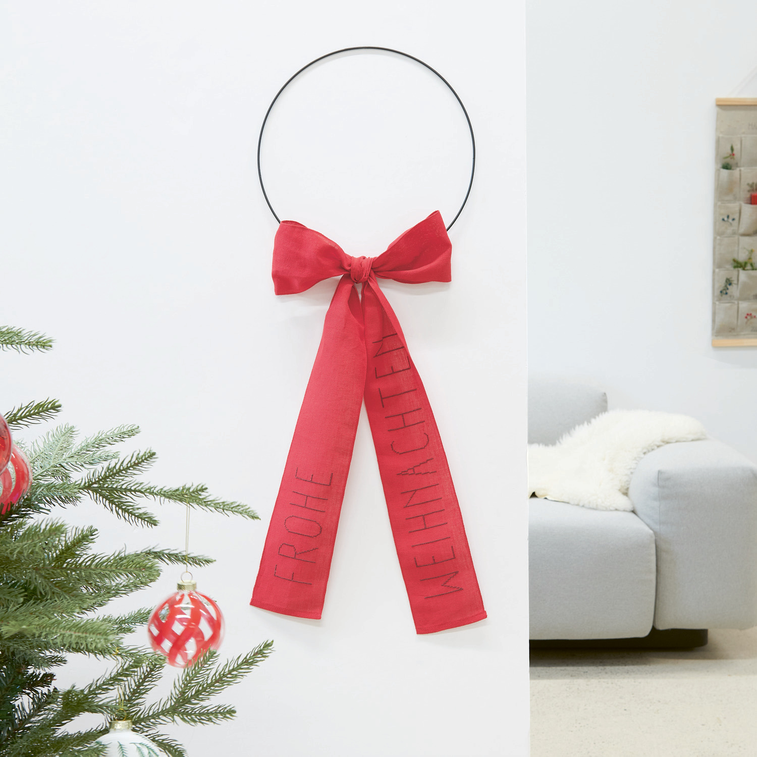 Embroidery book Put a Bow on It No. 185 from Rico Design Stickpackung Schleife Frohe Weihnachten: Roter Wandkranz mit Schleife, dekoriert für festliche Stimmung. Marke: Rico Design.