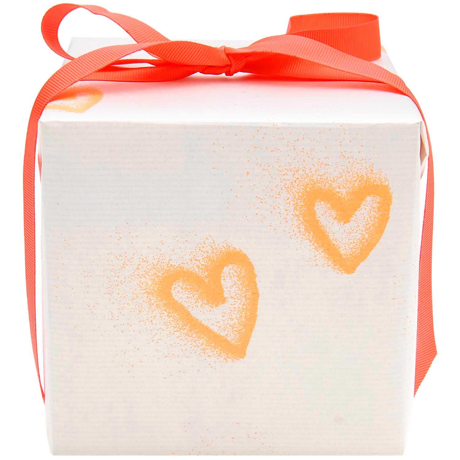 Paper Poetry Geschenkpapier Spray Herzen neon orange 200x70cm 70g/m² von Rico Design Paper Poetry Geschenkpapier mit neonorangen Herzen auf weißem Hintergrund, dekoriert mit rotem Band. Ideal für kreative Geschenkverpackungen.