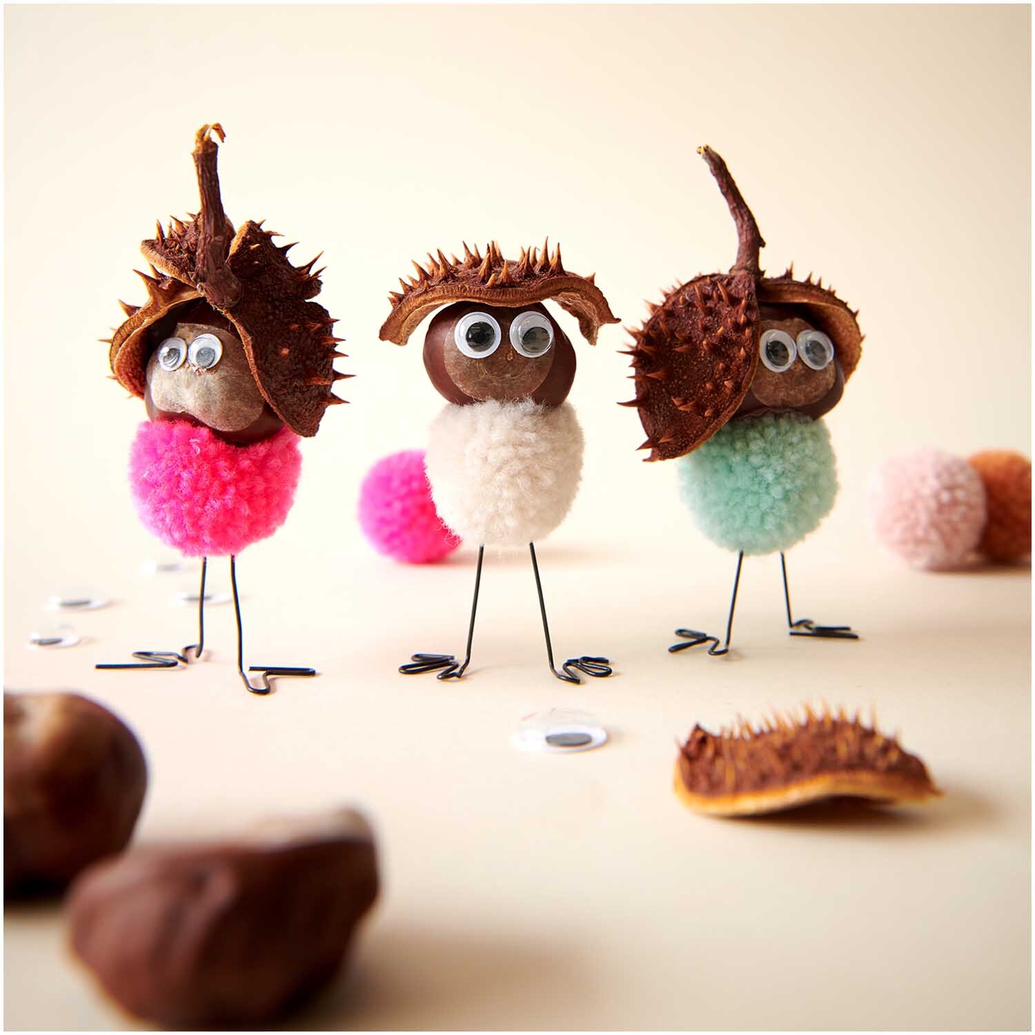 Garn Pompons 24 Stück Farbe Pastell Mix von Rico Design Garn Pompons 24 Stück von Rico Design in Pastell Mix, dekoriert als kreative Figuren mit Kastanienhüten und Wackelaugen auf einem hellen Hintergrund.