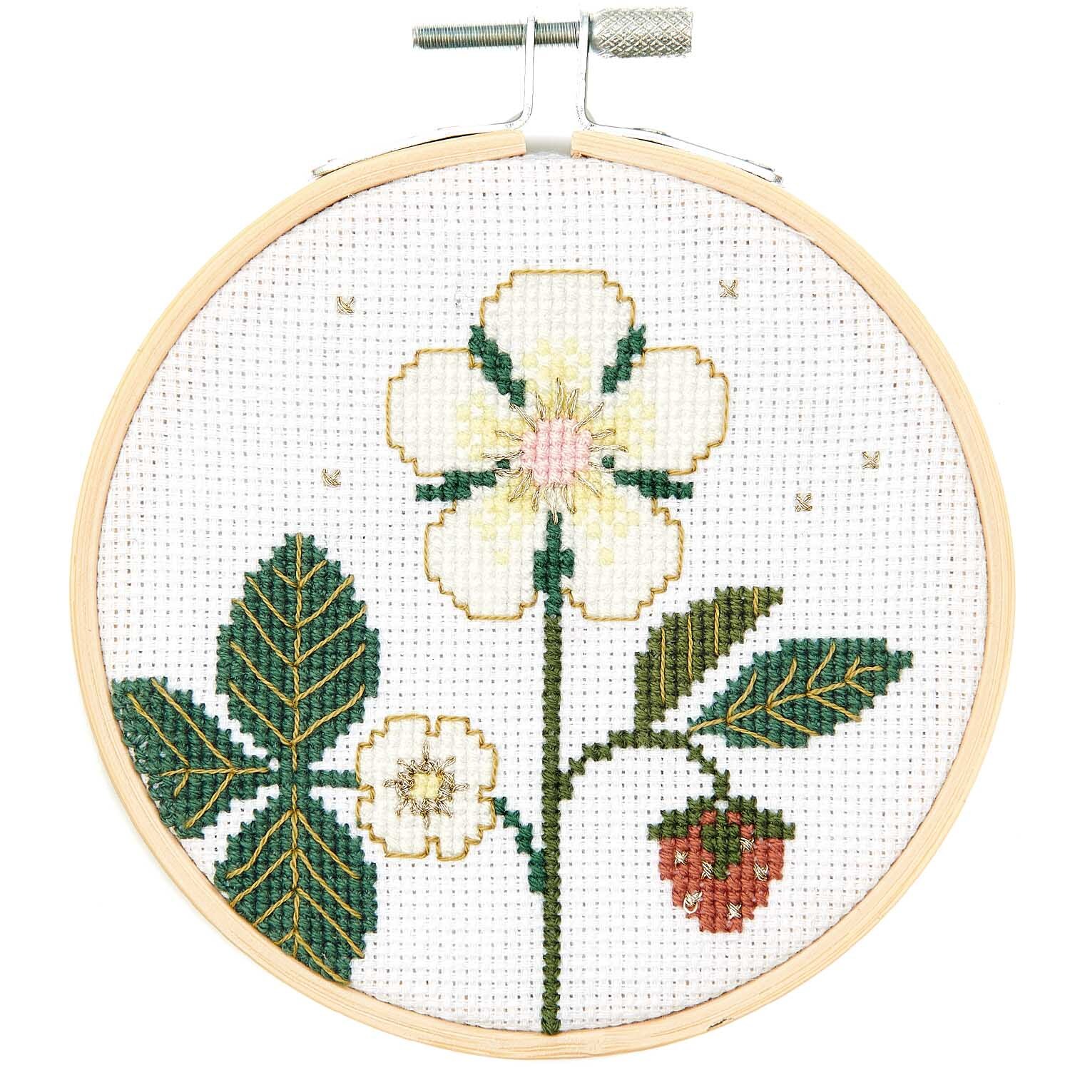 Stickpackung Bild Erdbeerblüte zeigt eine gestickte Erdbeerblüte mit grünen Blättern und einer roten Erdbeere.