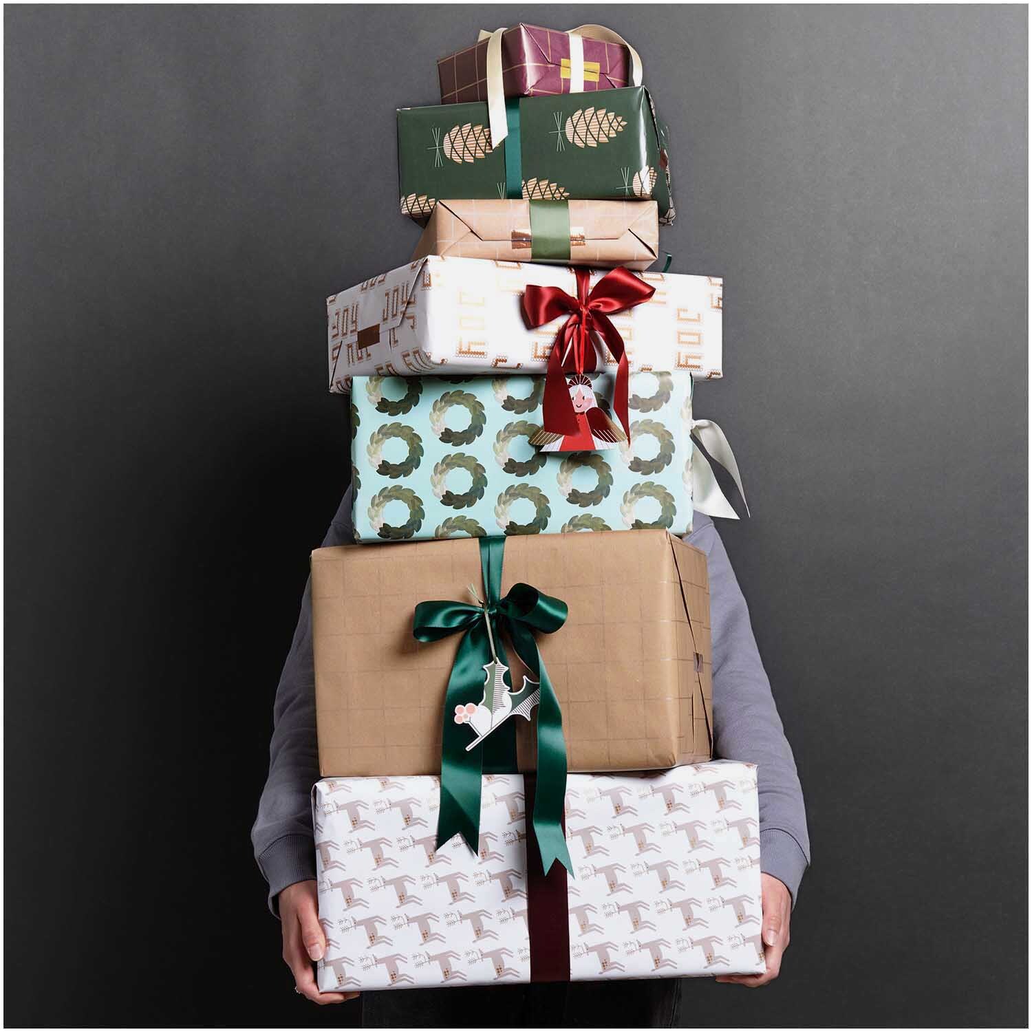 Paper Poetry Geschenkpapier Tannenzapfen: Stapel von Geschenken mit festlichen Mustern und Schleifen.