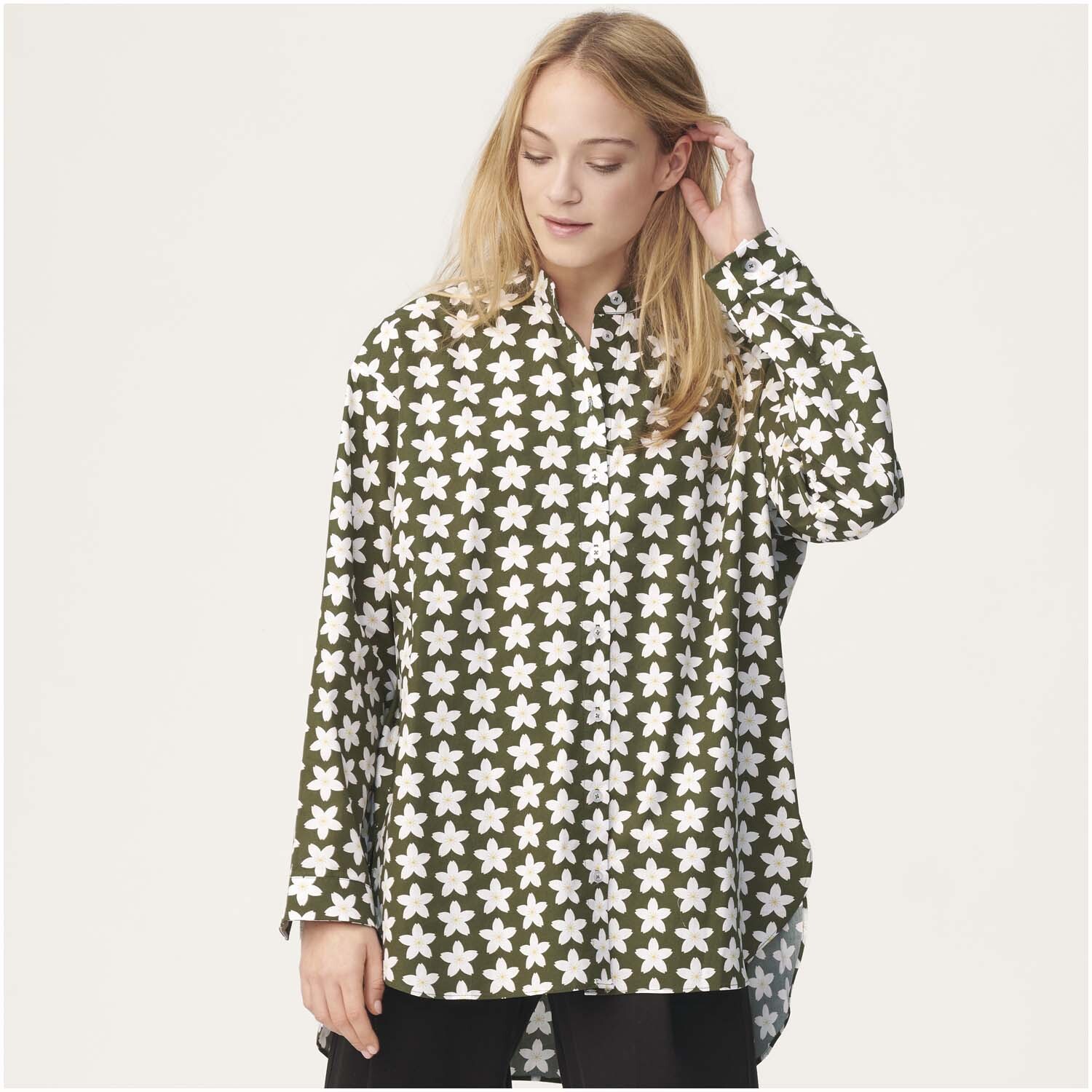 Meterware Baumwoll-Popelin oliv Kirschblüten von Rico Design Meterware Baumwoll-Popelin oliv Kirschblüten: Frau trägt olivgrünes Hemd mit weißen Kirschblüten von Rico Design.