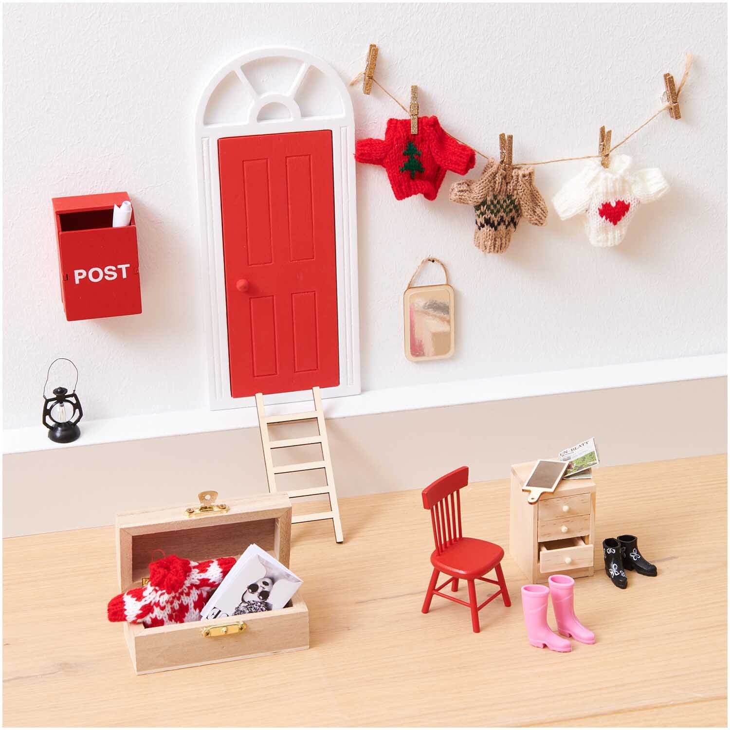 Miniatur Wichteltür mit Bogen, dekoriert mit roten und weißen Accessoires, von Rico Design.
