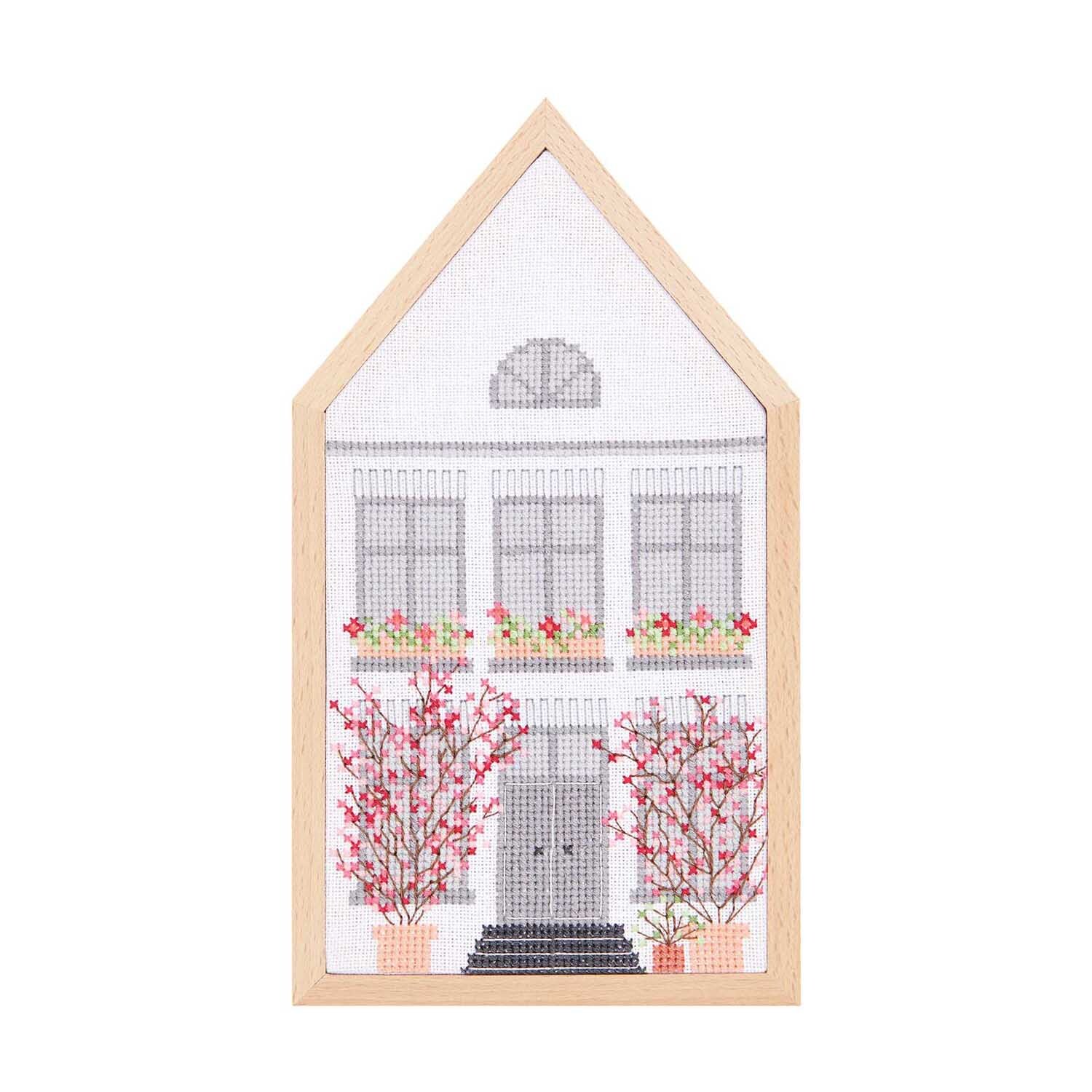 Stickpackung Frühlingshaus mittel zeigt ein gesticktes Haus mit blühenden Bäumen, 12x22,5cm. Ideal für kreative Projekte.