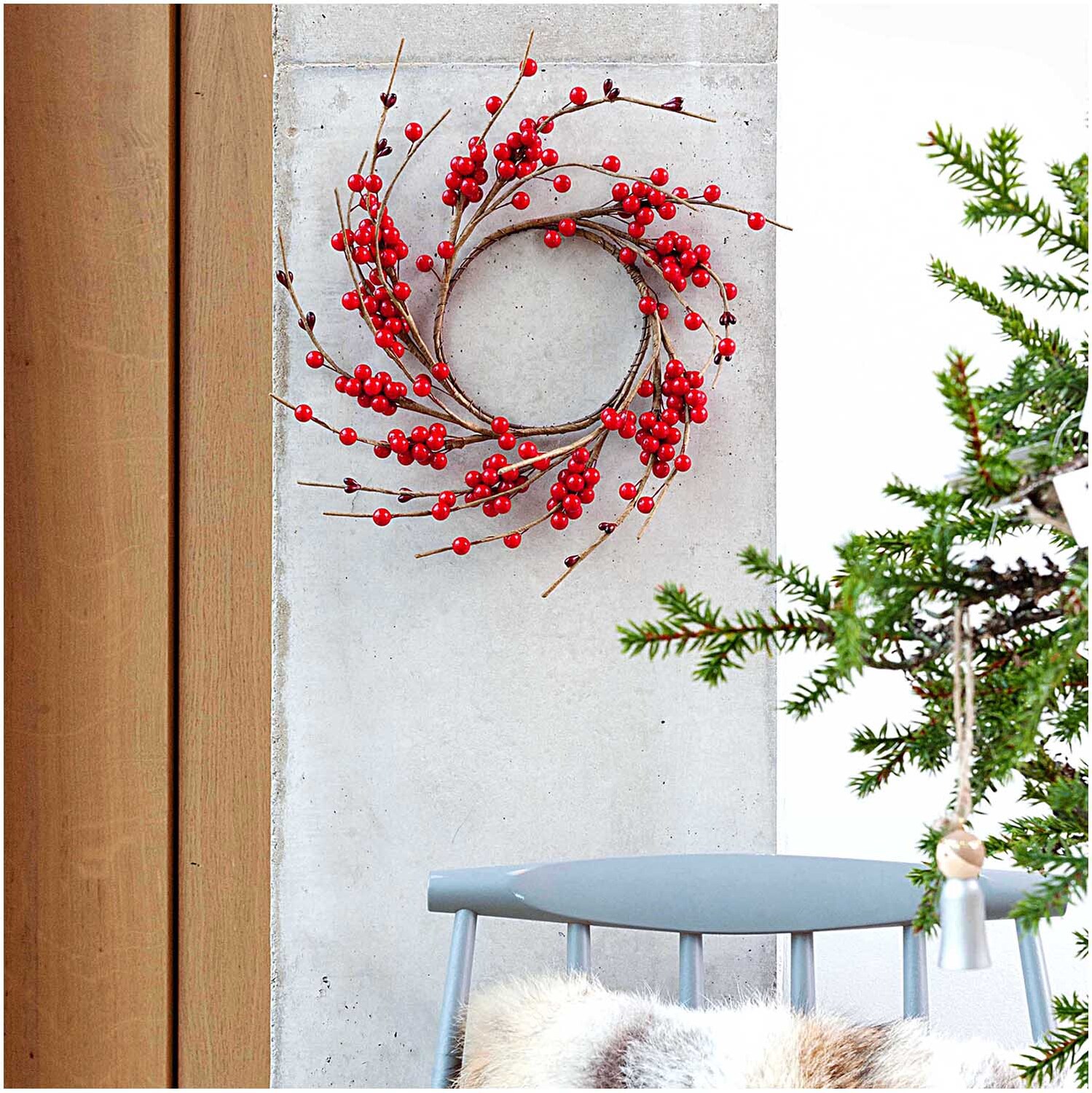 Beerenkranz rot Ø12cm: Dekorativer Kranz mit roten Beeren an einer Wand, ideal für festliche Anlässe.