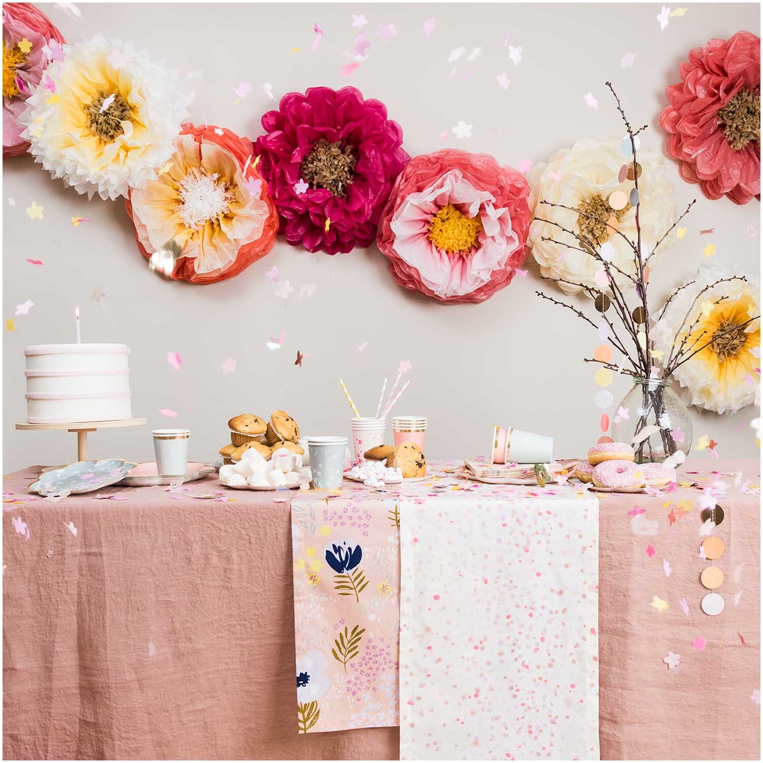 Pappbecher Blüten rosa 200ml 12 Stück von Rico Design Pappbecher Blüten rosa 200ml 12 Stück, dekoriert auf einem Tisch mit rosa Tischdecke und großen Papierblumen im Hintergrund.