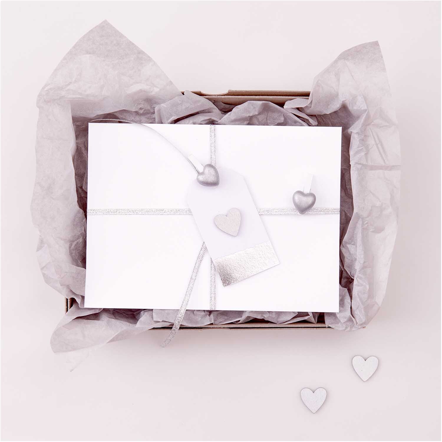 Holzstreu Herz 48 Stück Farbe Silber von Rico Design Holzstreu Herz 48 Stück: Elegante silberne Herzen von Rico Design auf weißem Geschenkpapier.