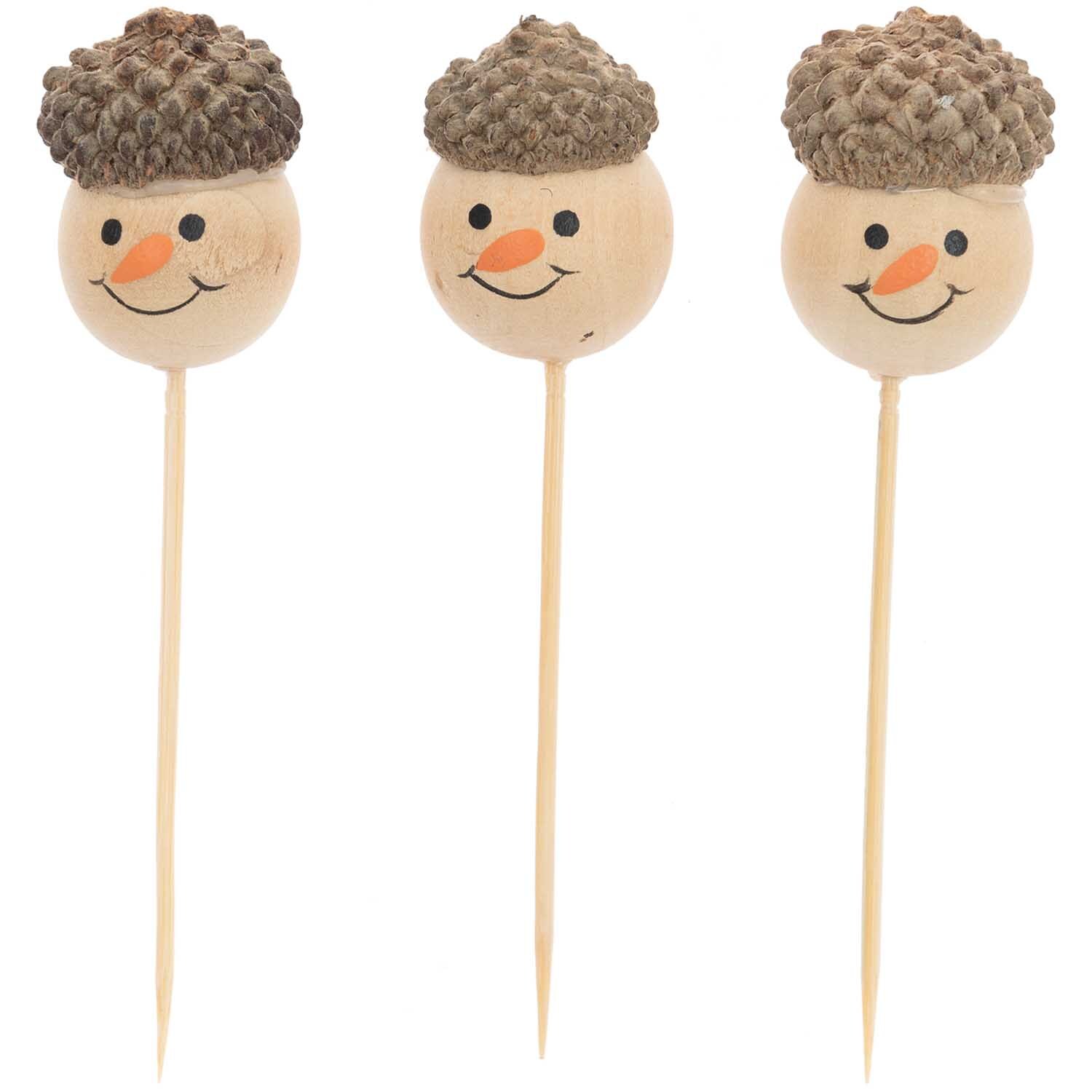Sticks Schneemann natur 3 Stück von Rico Design zeigen drei lächelnde Schneemann-Gesichter auf Holzstäben.