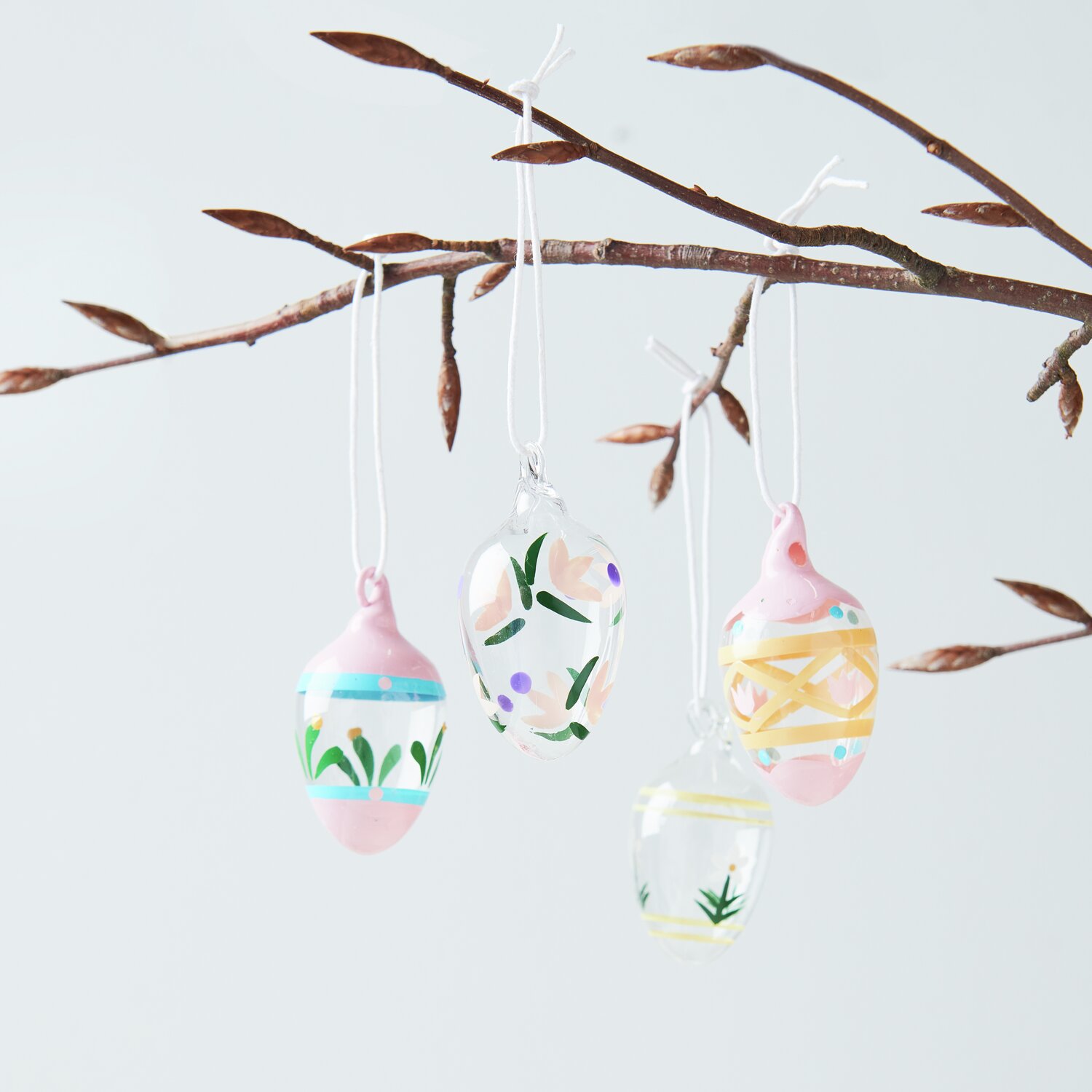 Glas Eier Blumen handbemalt Ø3x6cm 4-teilig von Rico Design Glas Eier Blumen handbemalt: Vier handbemalte Glaseier mit floralen Mustern an einem Ast hängend. Größe Ø3x6cm, 4-teilig von Rico Design.