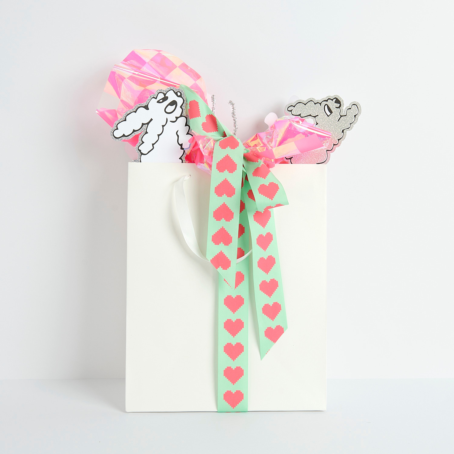 Paper Poetry Geschenkfolie Schachbrett Pink 200x70cm 80g/m² von Rico Design Paper Poetry Geschenktüte mit pinker Schachbrett-Geschenkfolie und Hasen-Pickern, verziert mit Herzband.